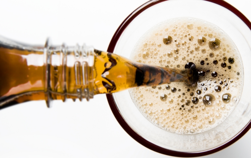 Pouring a glass of cola into a glass from a bottle