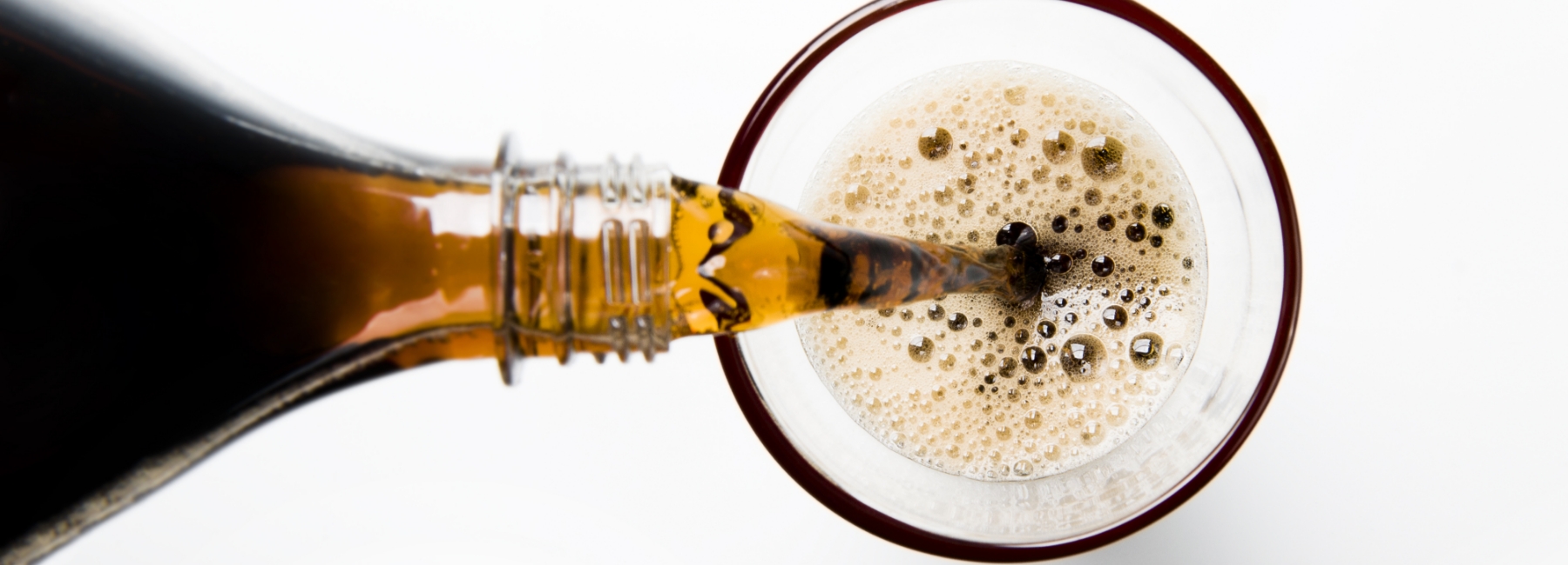 Pouring a glass of cola into a glass from a bottle