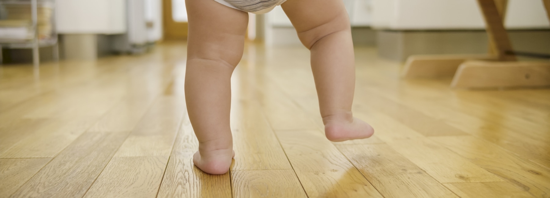 Baby feet walking on wooden floor