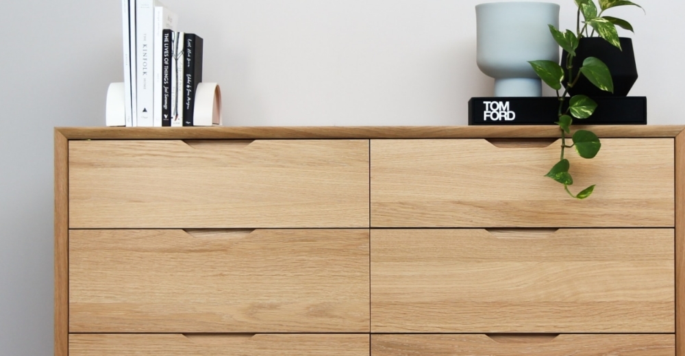 Wooden cabinet with books, vase and plant