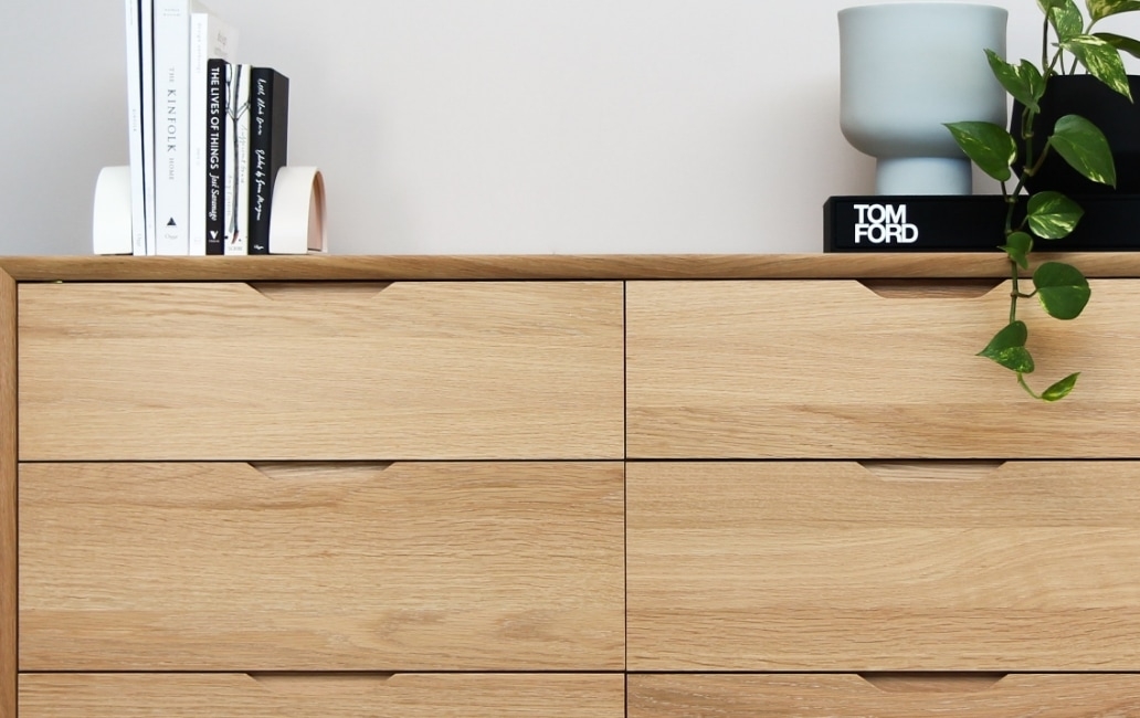 Wooden cabinet with books, vase and plant