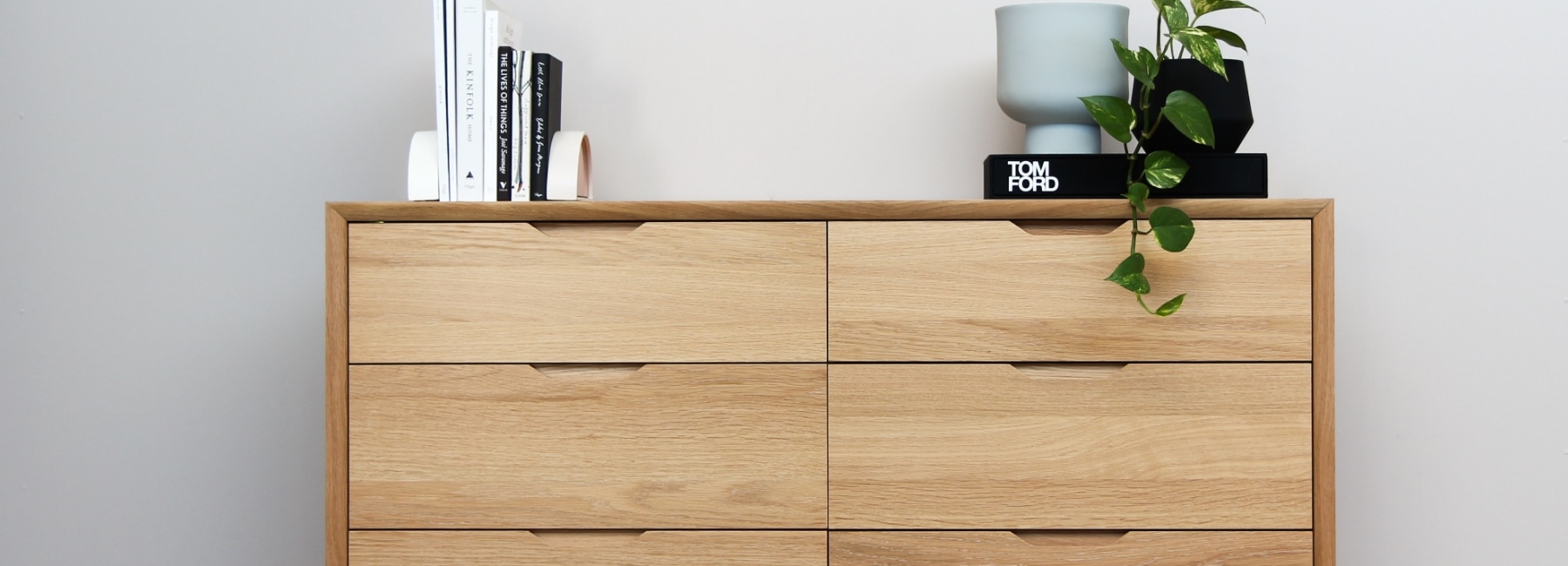 Wooden cabinet with books, vase and plant