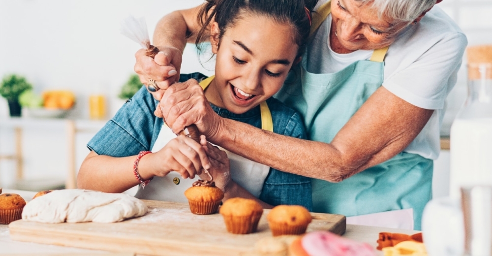 A woman with a girl decorating cupcakes