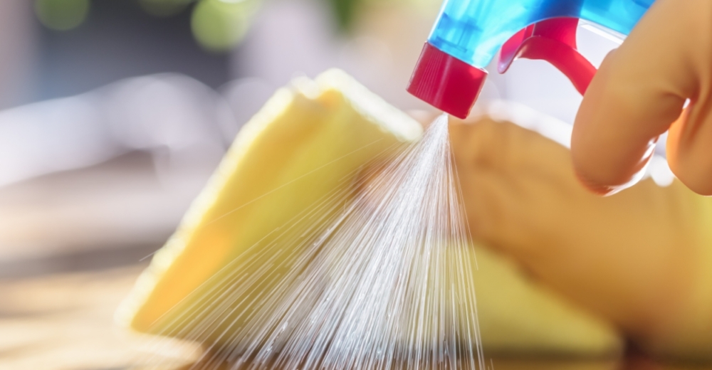 Person cleaning with cloth and spray