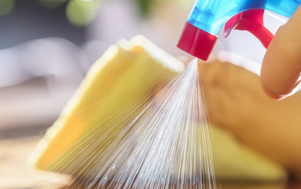 Person cleaning with cloth and spray