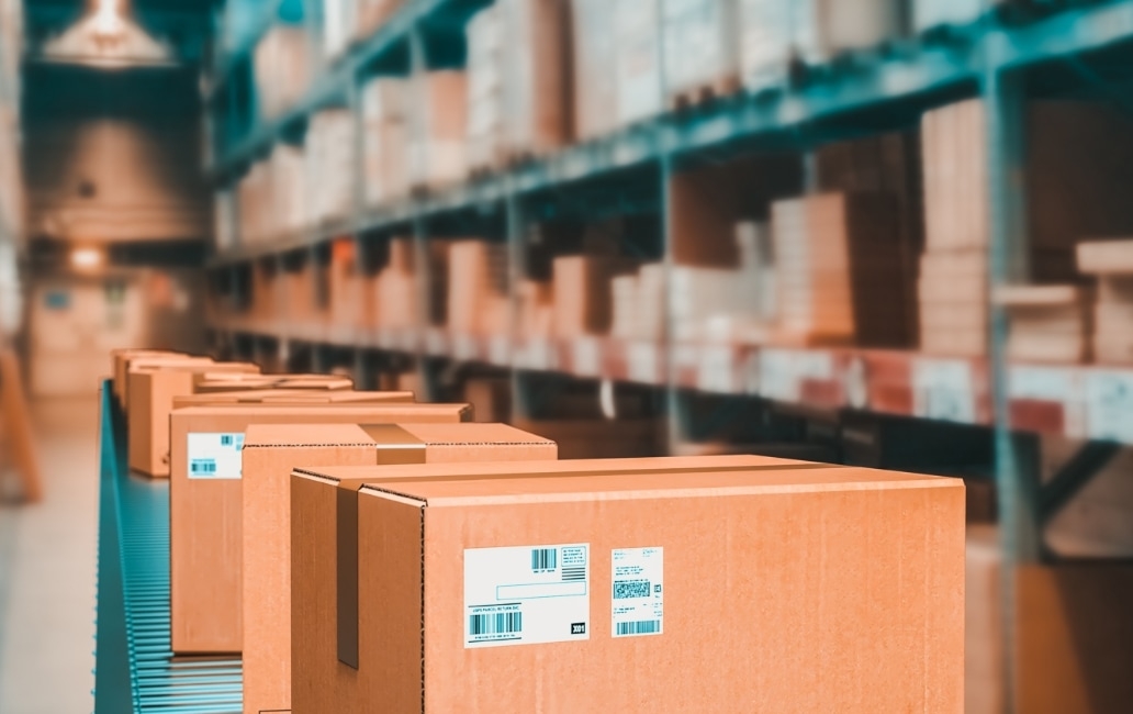 Warehouse with shelves with stored products and an aisle with cardboard boxes